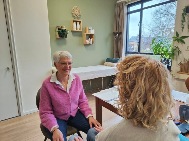 twee vrouwen die deelnemen aan de opleiding spiritueel coach. Ze zitten tegenover elkaar, kijken elkaar aan en doen een oefening